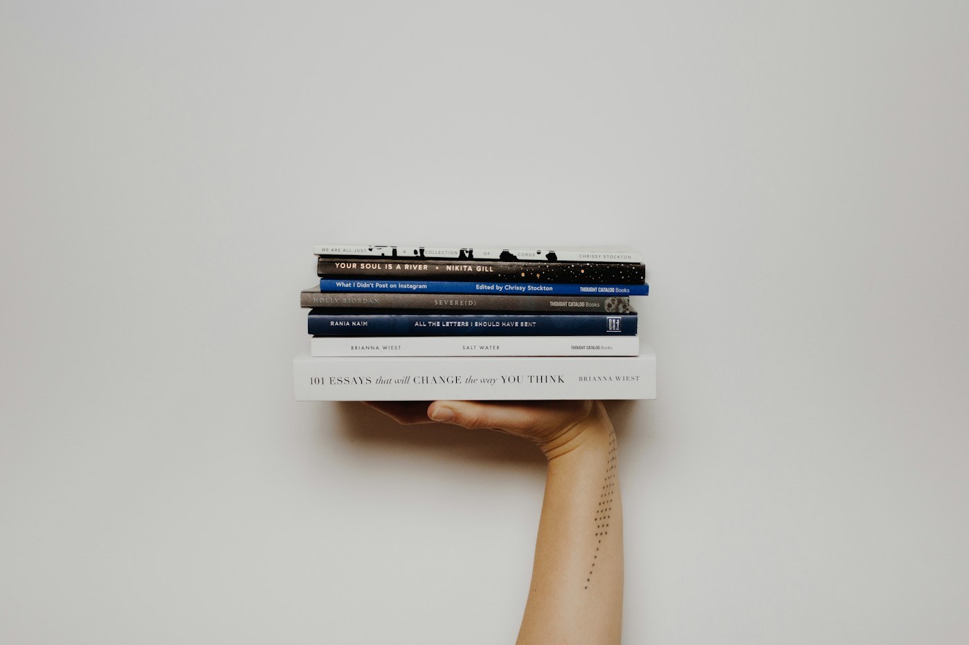 A small stack of books held against a pale background